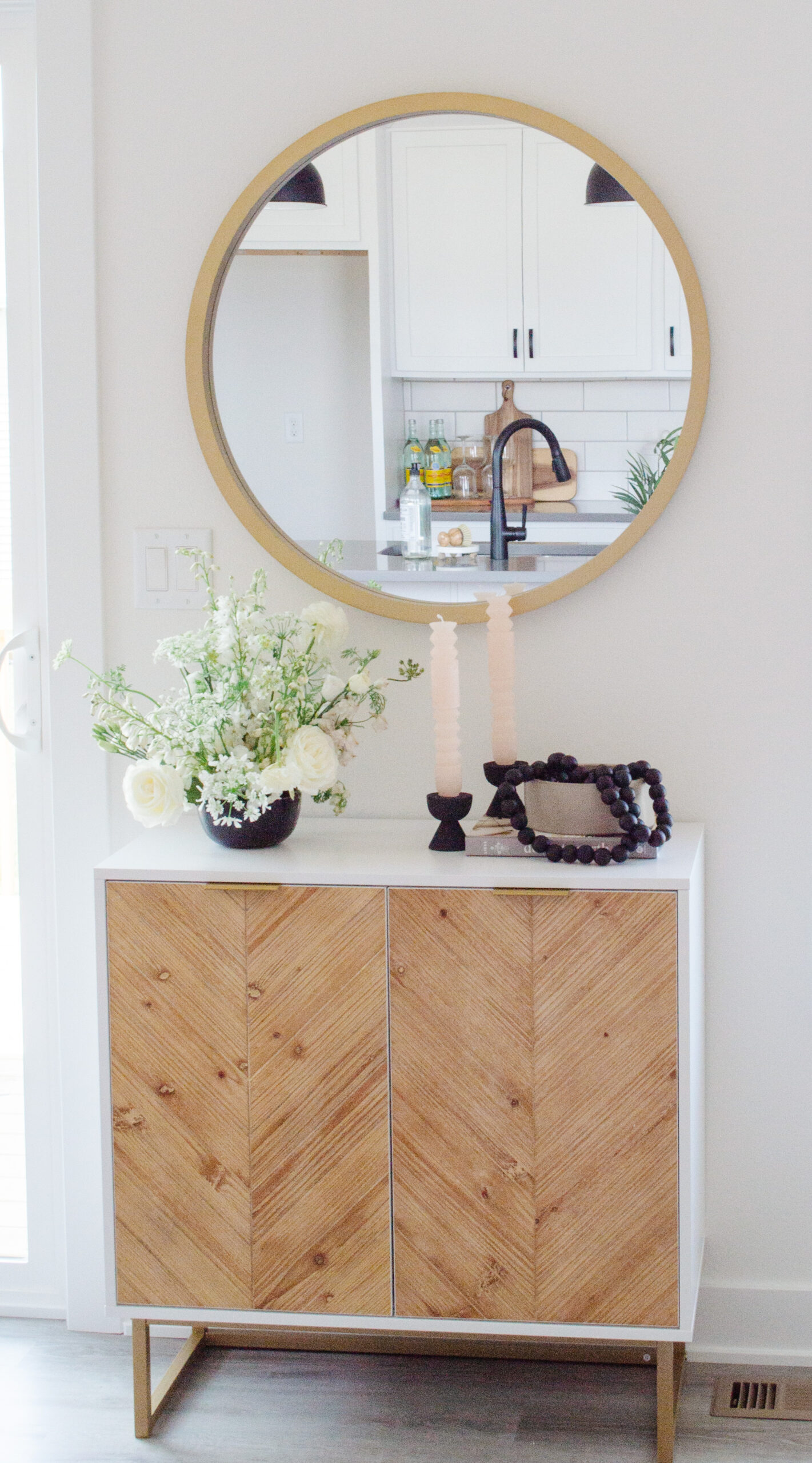 Modern console table with gold mirror and organic decor style.
